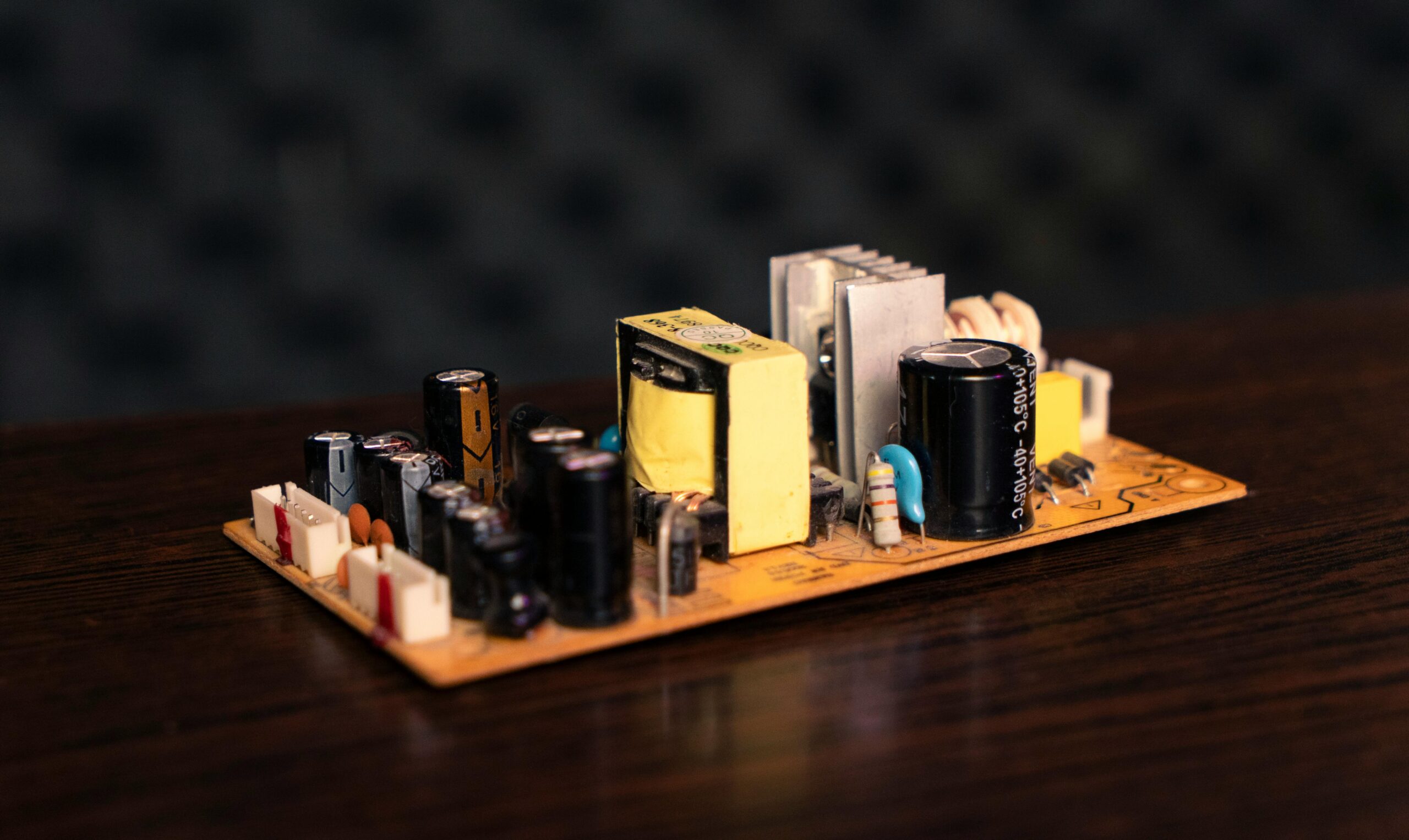 Close-up of an electronic circuit board showcasing capacitors, resistors, and transformers.